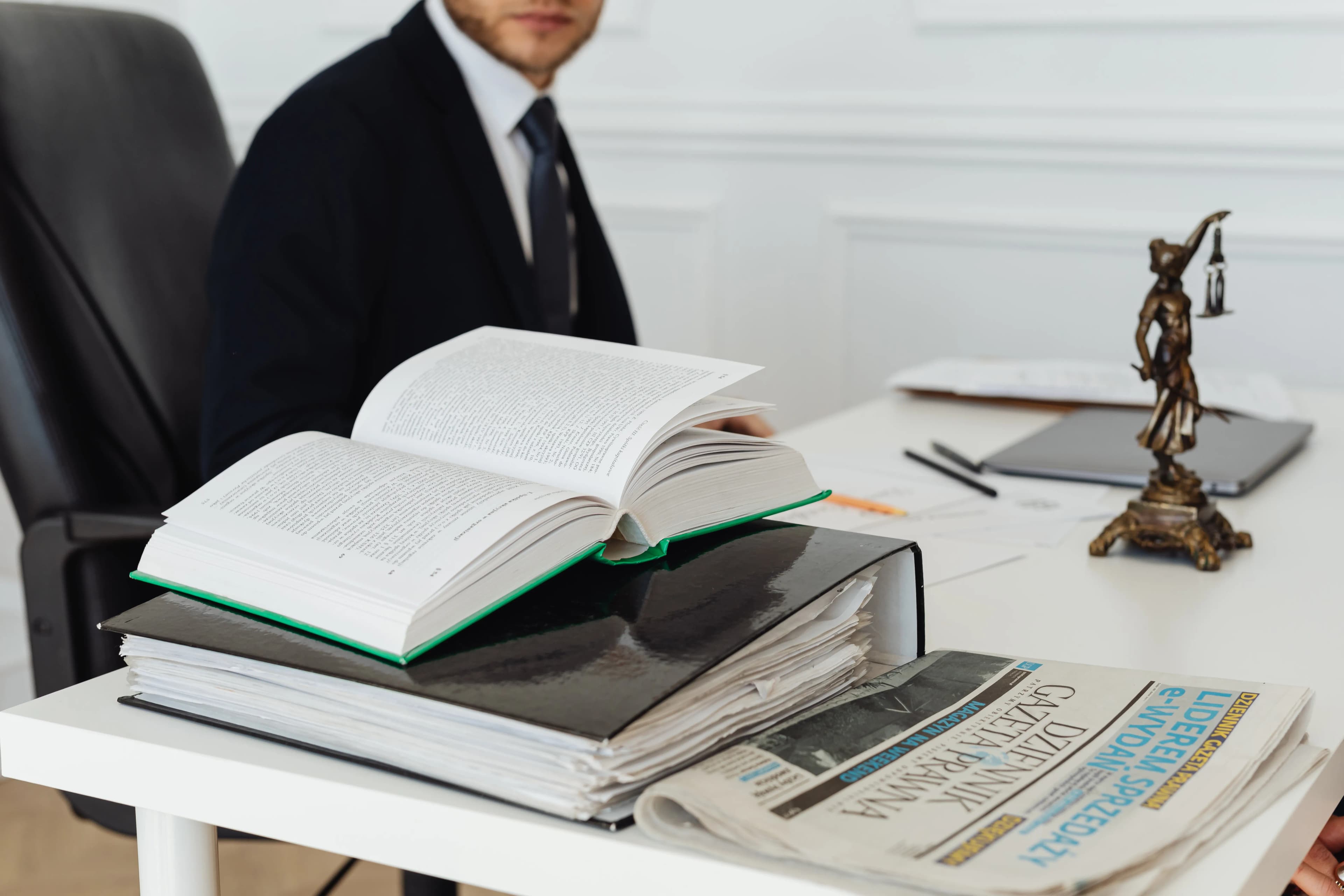 محامٍ يعمل على مكتبه وسط الكتب والمستندات القانونية
